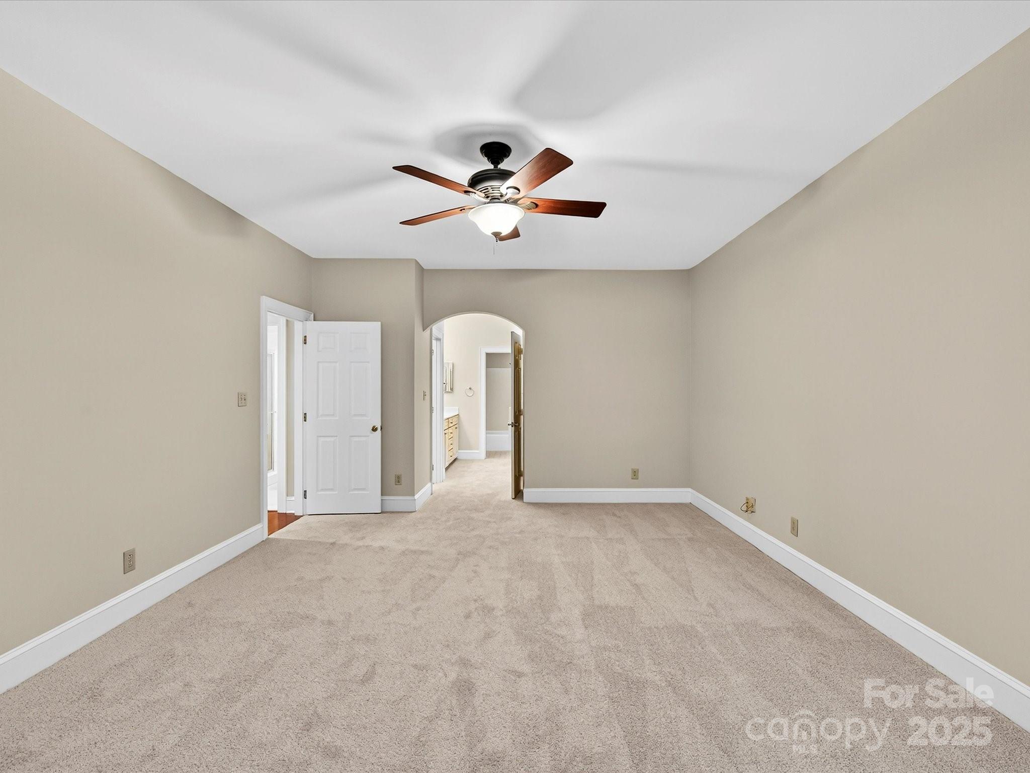 325 Queens Road, Unit 2 Charlotte, NC 28204 - Photo 13 of 25 an empty room with chandelier fan and windows