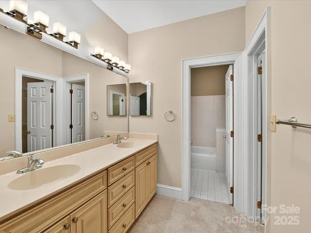 a spacious bathroom with a double vanity sink mirror and shower