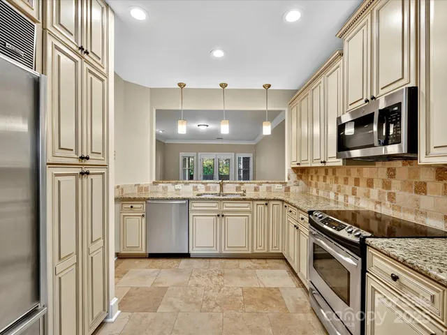 a kitchen with stainless steel appliances granite countertop a sink and stove top oven