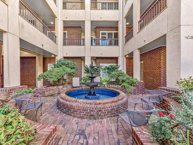 a view of white house with plants and outdoor seating