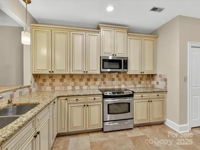 a kitchen with white cabinets and stainless steel appliances