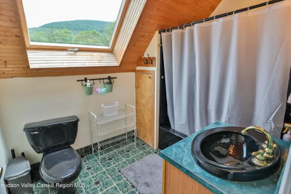 a bathroom with a toilet and a chair