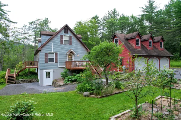 a view of a house with a yard potted plants and a bench