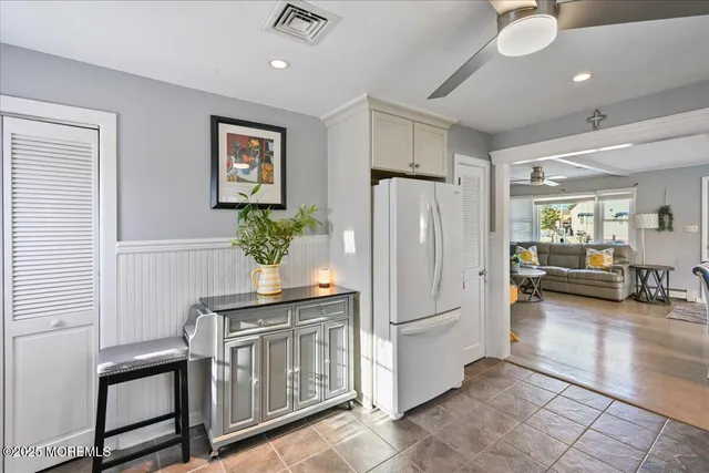 a hall with white cabinets and wooden floor