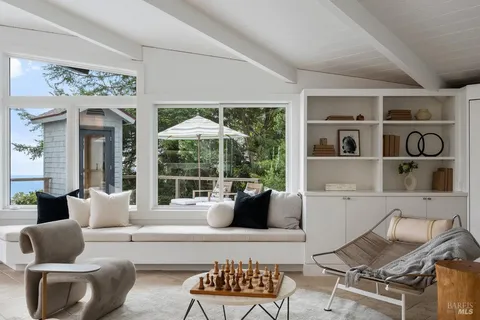 a living room with furniture a rug and kitchen view
