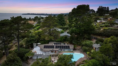a view of a roof deck with furniture and a table and chairs under an umbrella