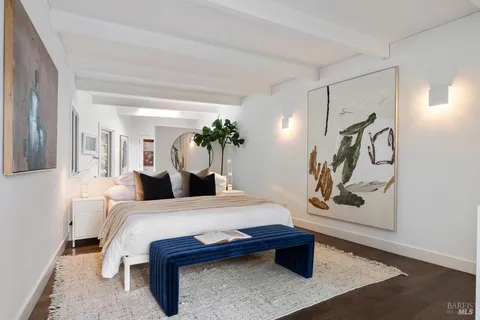 a bedroom with a bed and a painting on the wall