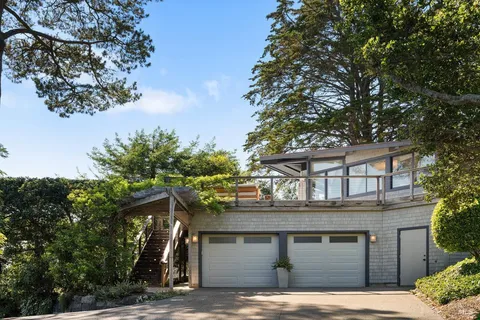 a living room with furniture large windows and a chandelier