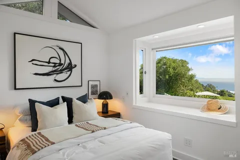 a view of a dining room with furniture and large windows