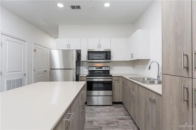 a kitchen with kitchen island a sink stove and refrigerator
