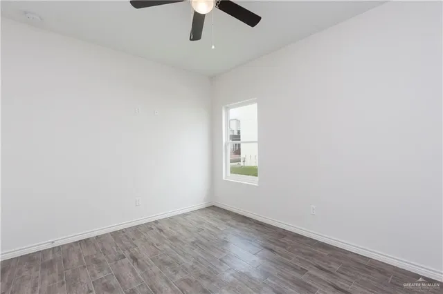 an empty room with a window and ceiling fan