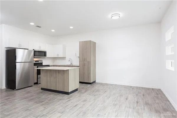 a kitchen with stainless steel appliances granite countertop a refrigerator and a stove top oven