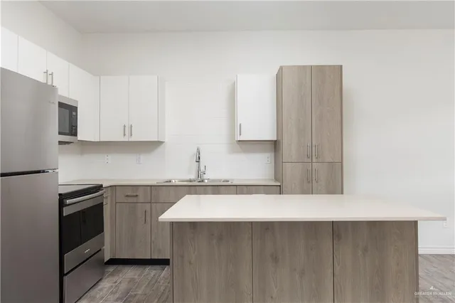 a kitchen with stainless steel appliances a sink stove and refrigerator