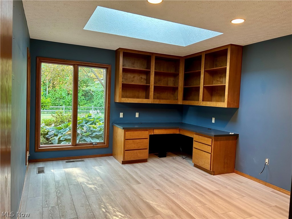 8763 Timber Edge Drive North Ridgeville, OH 44039 - Photo 27 of 40 Unfurnished office with built in desk, a textured ceiling, a skylight, and light hardwood / wood-style flooring