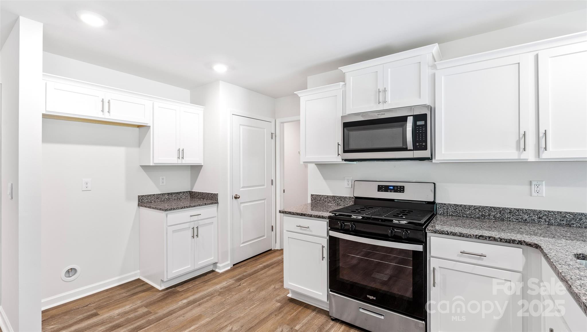 10 Callie River Clyde, NC 28721 - Photo 15 of 23 a kitchen with stainless steel appliances a white stove a microwave and a hard wood floors
