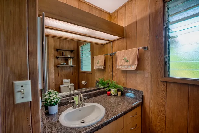a bathroom with a granite countertop sink and a mirror