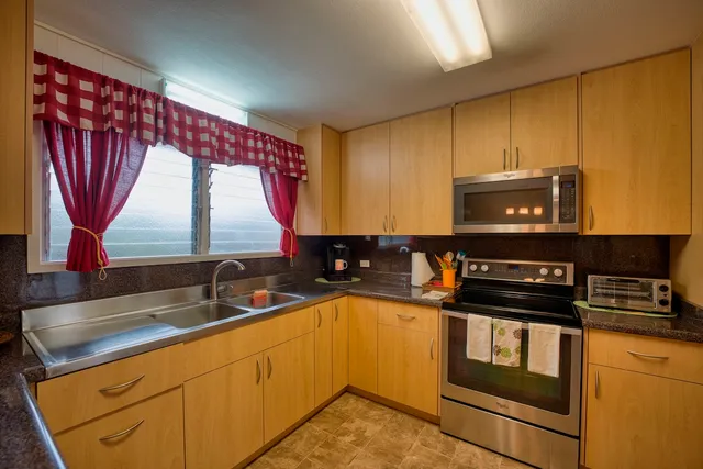 a kitchen with stainless steel appliances a sink a stove and a microwave