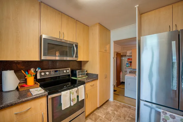 a kitchen with stainless steel appliances granite countertop a refrigerator and a stove top oven