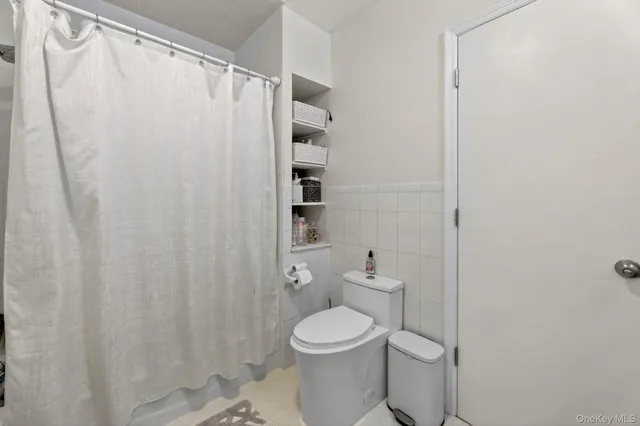 a white toilet sitting next to a shower curtain