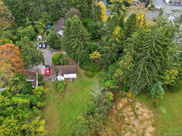 an aerial view of residential house with green space and trees all around