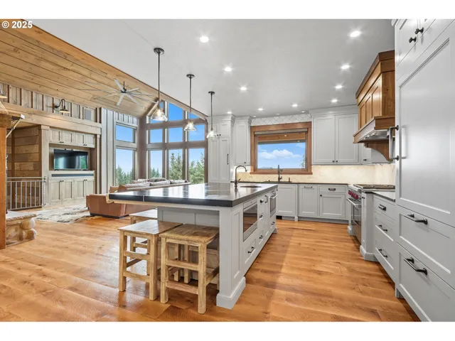 a kitchen with kitchen island granite countertop a sink cabinets and wooden floor