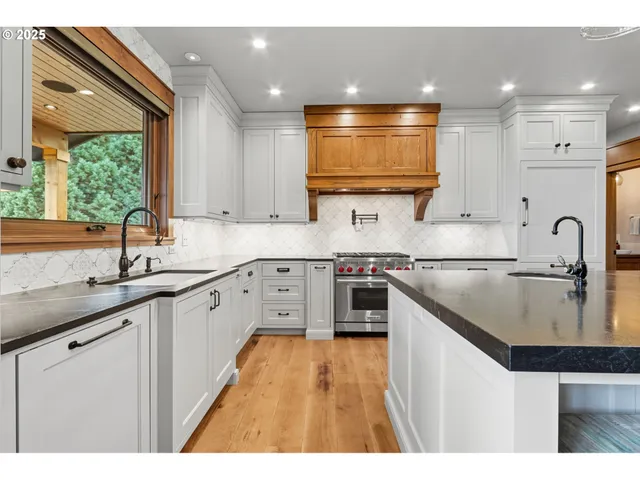 a kitchen with stainless steel appliances granite countertop a sink stove and cabinets