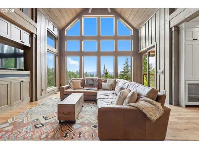 a living room with furniture a flat screen tv and a floor to ceiling window