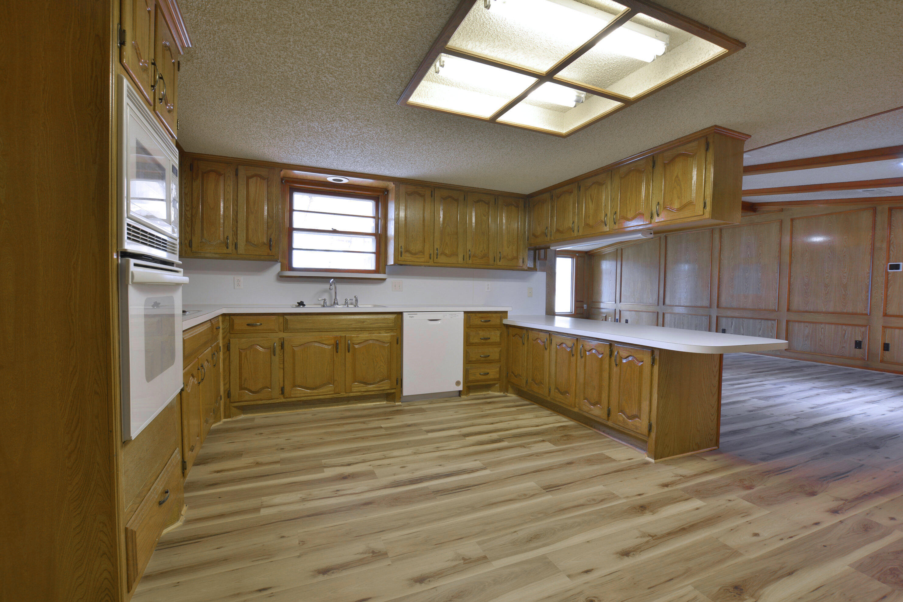 5224 9th Street Lubbock, TX 79416 - Photo 14 of 26 a large kitchen with stainless steel appliances granite countertop a stove a sink and a wooden floors