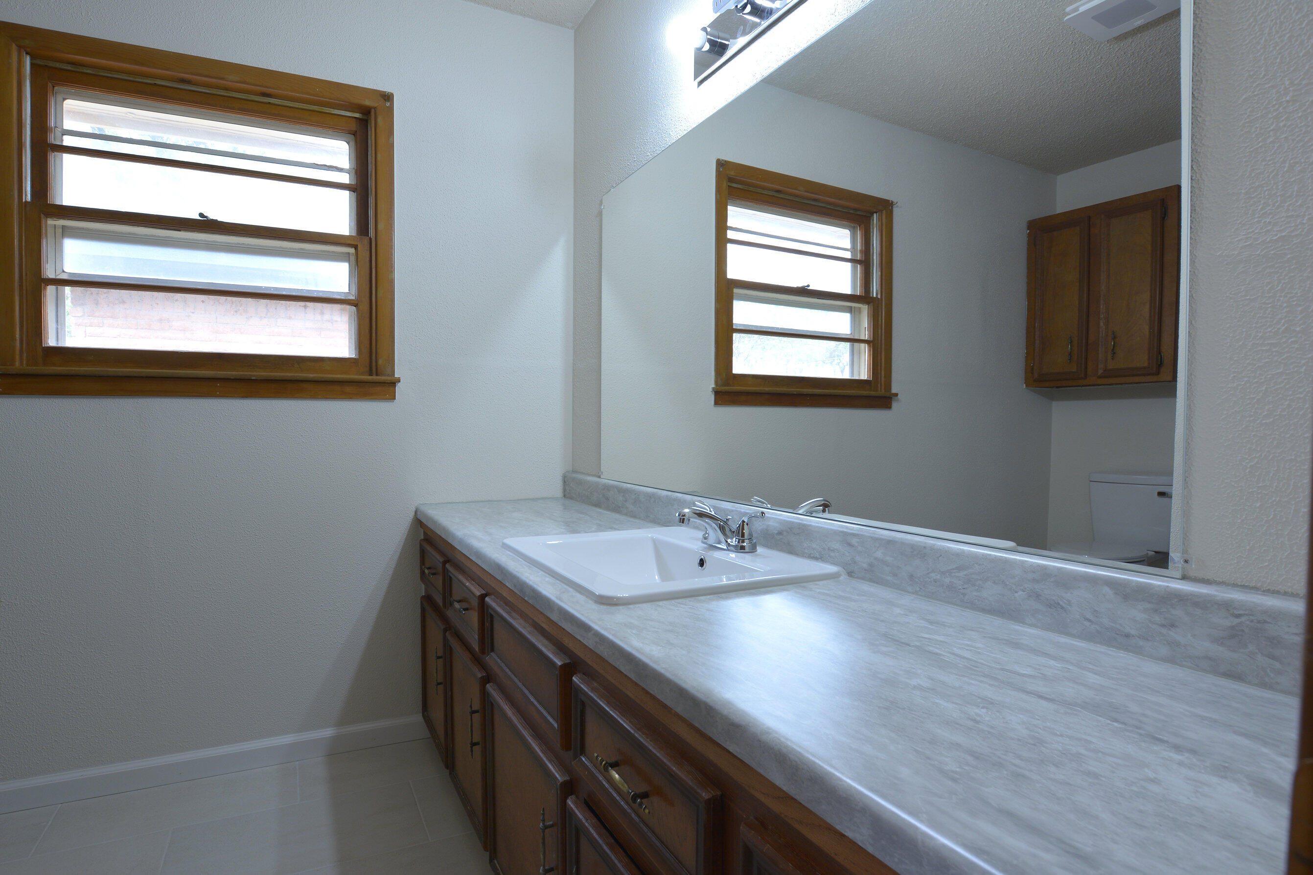 5224 9th Street Lubbock, TX 79416 - Photo 17 of 26 a bathroom with a sink a vanity and a window