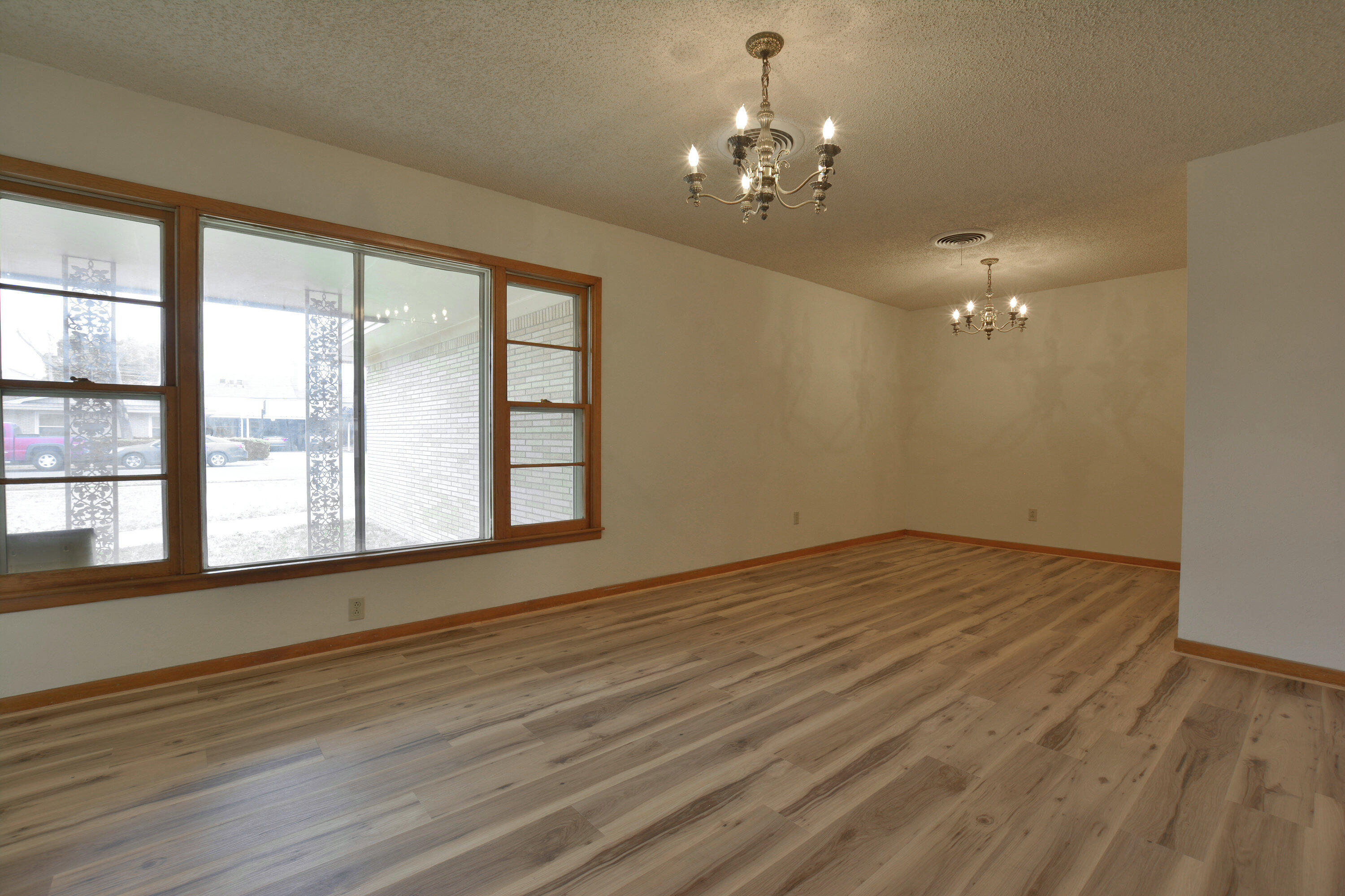 5224 9th Street Lubbock, TX 79416 - Photo 5 of 26 a view of an empty room with wooden floor and a window