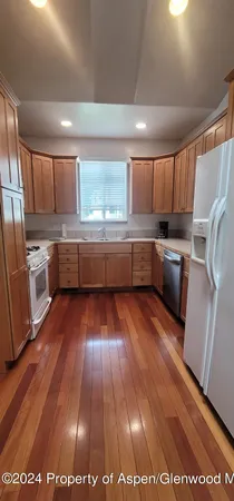 a kitchen with wooden floors and refrigerator