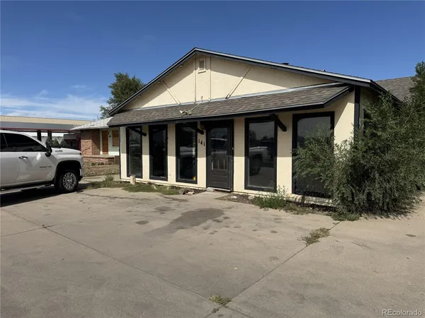 a view of a house with a parking space and a car parked in front of it