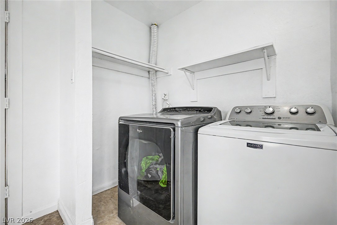 5357 Indian Wells Road Las Vegas, NV 89110 - Photo 35 of 39 A dedicated utility space offers practical laundry solutions with included appliances and convenient shelving.