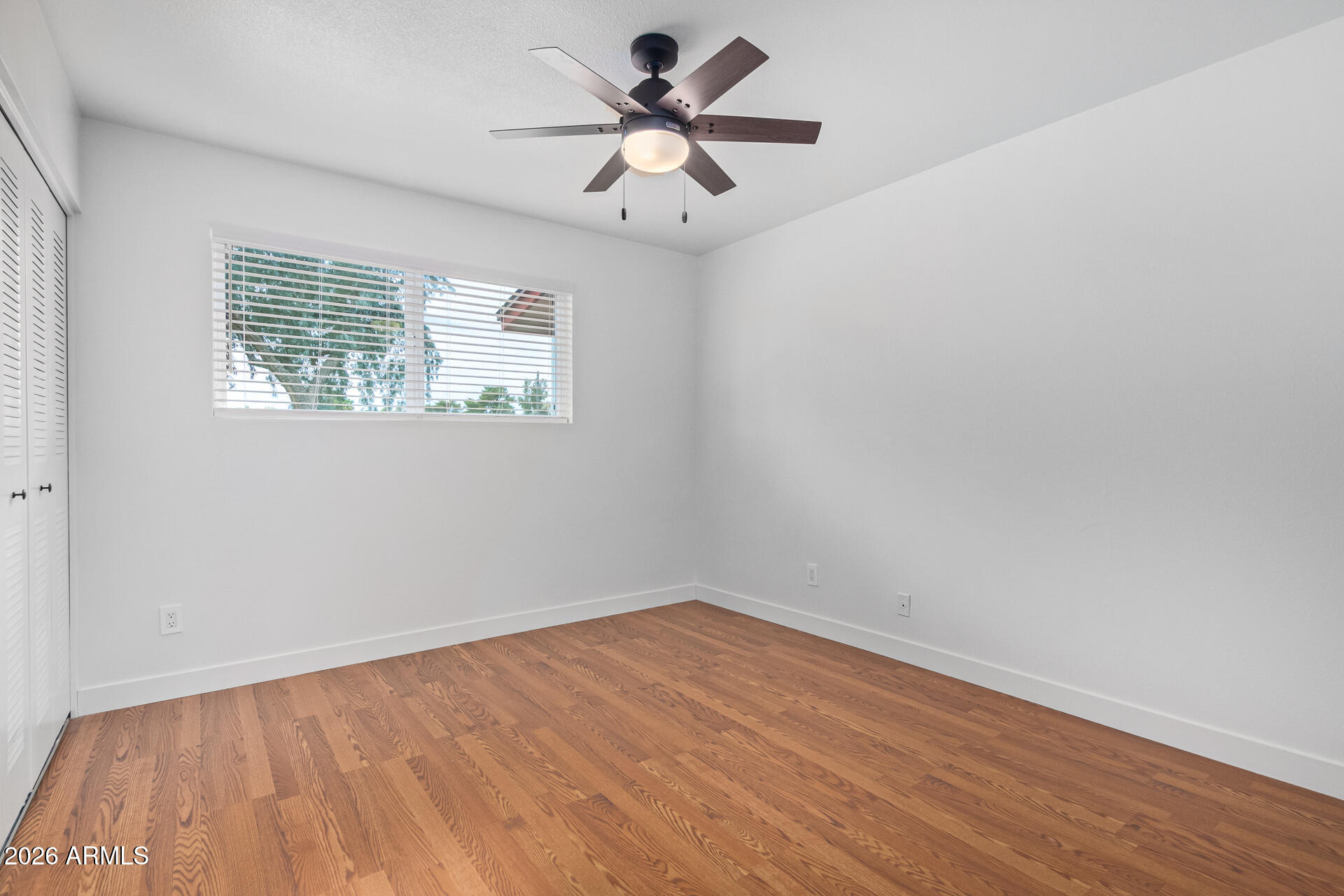 2111 South River Drive Tempe, AZ 85282 - Photo 15 of 26 wooden floor in an empty room with a window