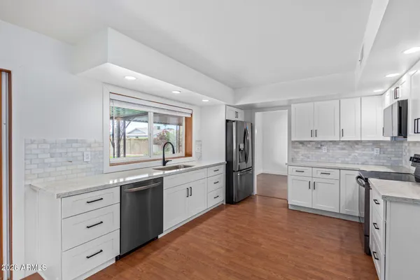 a large kitchen with granite countertop cabinets stainless steel appliances a sink and a window
