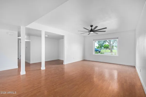 an empty room with window and a ceiling fan