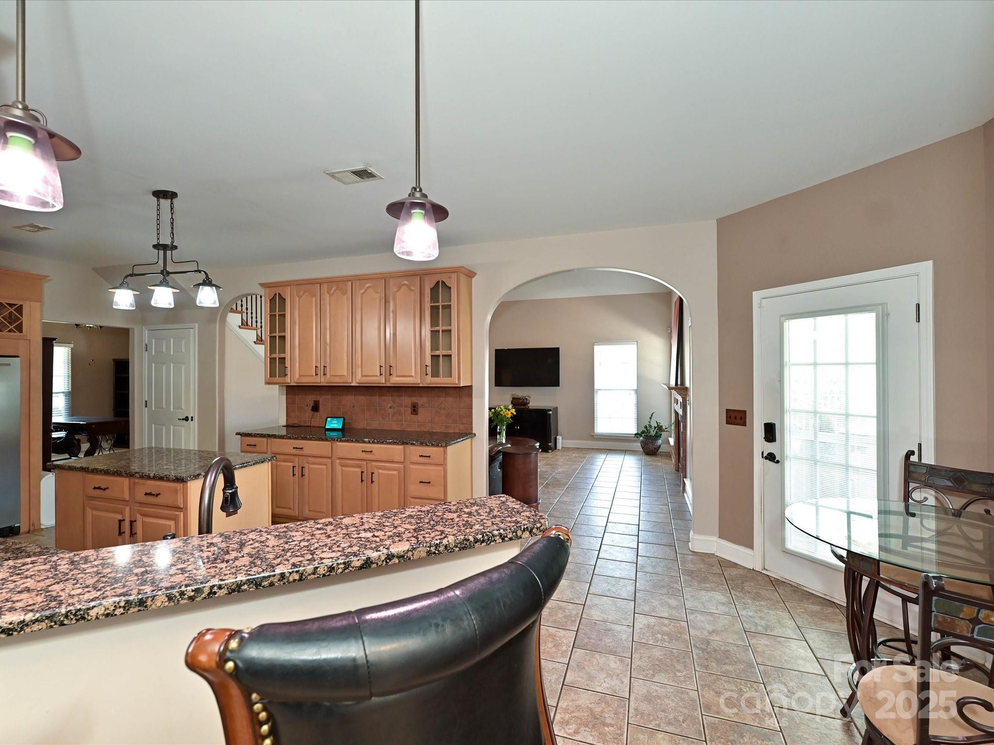4562 Lanstone Court Southwest Concord, NC 28027 - Photo 15 of 30 a large hall with kitchen island granite countertop a sink a stove and a dining table view