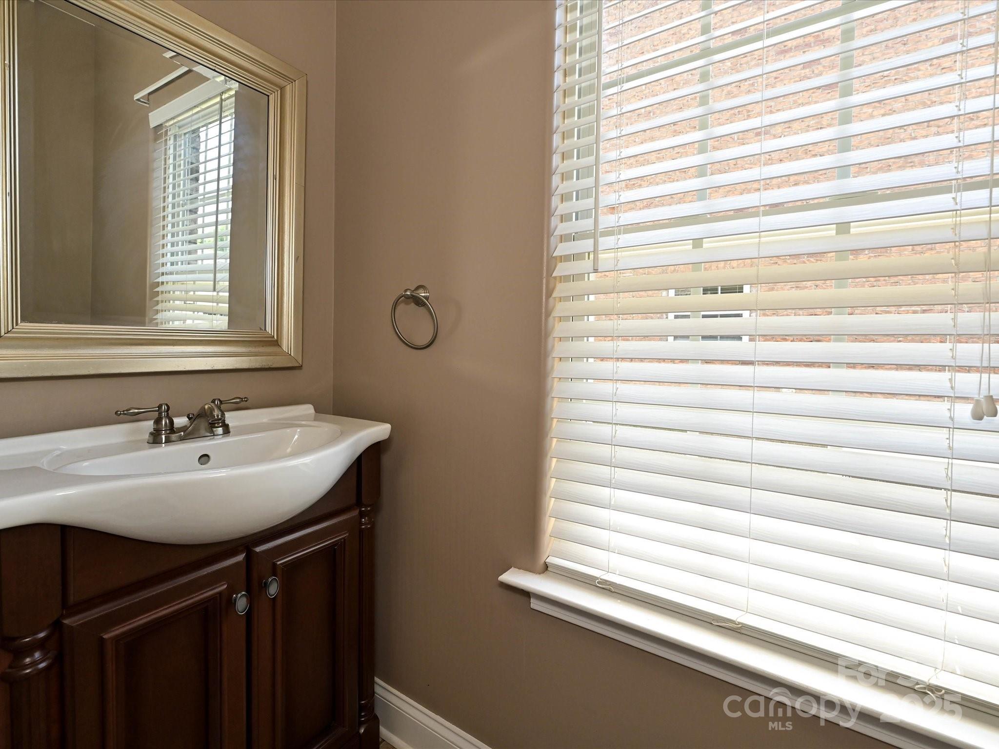 4562 Lanstone Court Southwest Concord, NC 28027 - Photo 18 of 30 a bathroom with a sink a vanity and a window