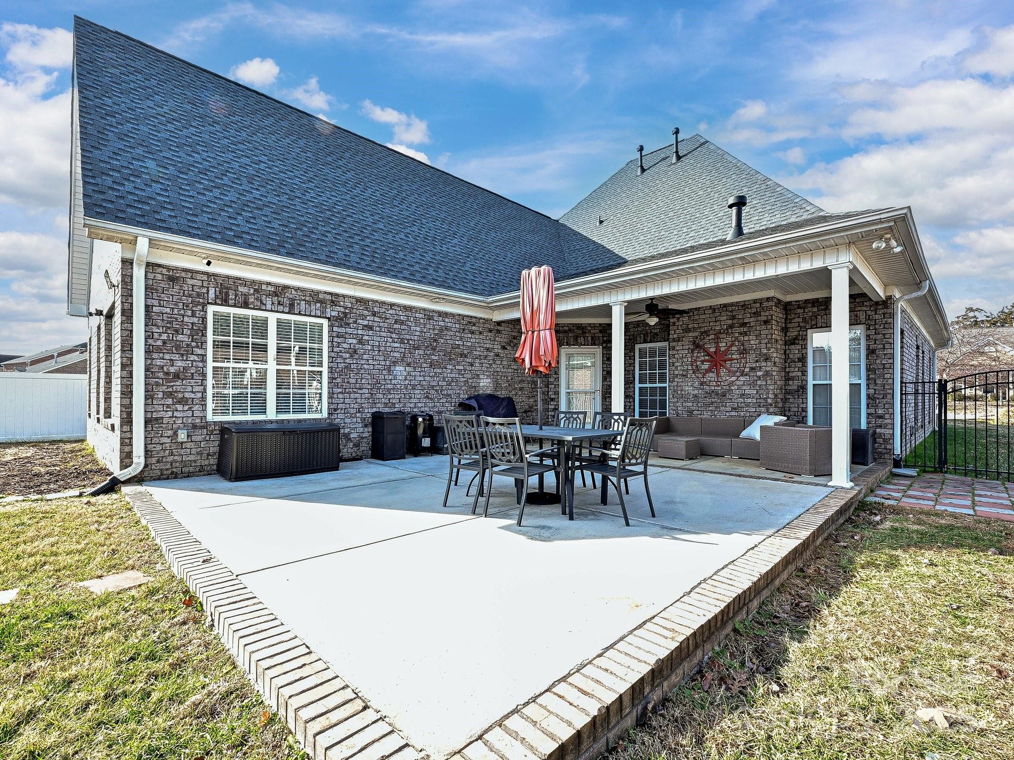 4562 Lanstone Court Southwest Concord, NC 28027 - Photo 25 of 30 a view of a patio with dining table and chairs with wooden floor and fence