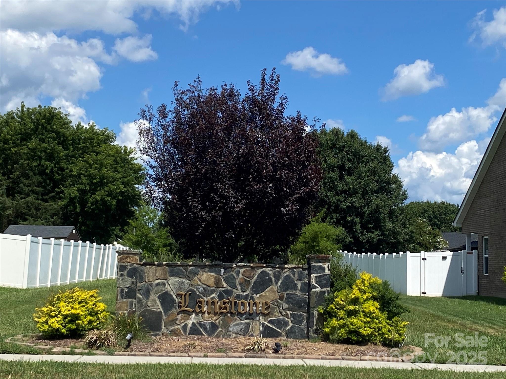 4562 Lanstone Court Southwest Concord, NC 28027 - Photo 29 of 30 a view of a yard with flower plants and wooden fence