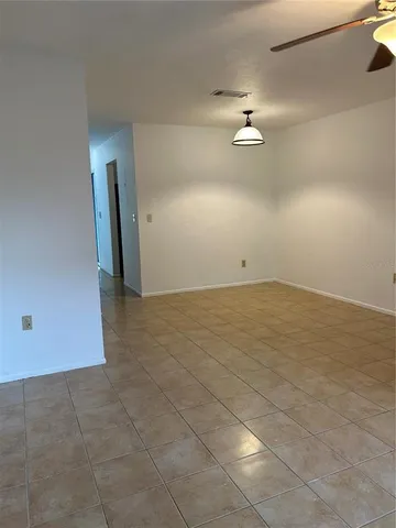 an empty room with an entryway and fan