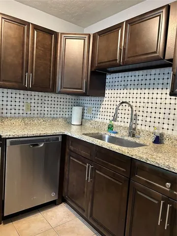 a kitchen with a sink a stove and cabinets