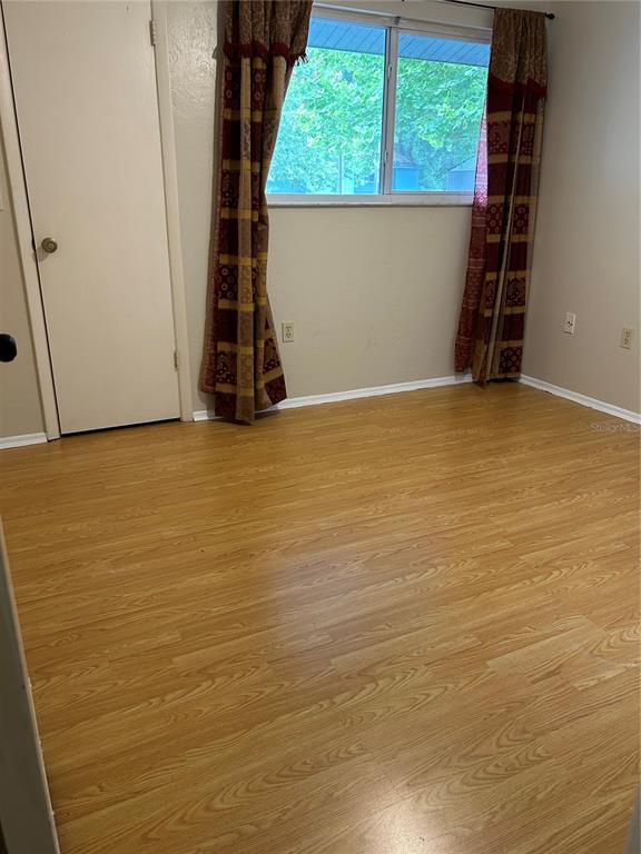 3936 Southwest 26th Terrace, Unit B Gainesville, FL 32608 - Photo 10 of 15 a view of an empty room with wooden floor and a window