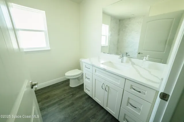 a bathroom with a sink a toilet and a window