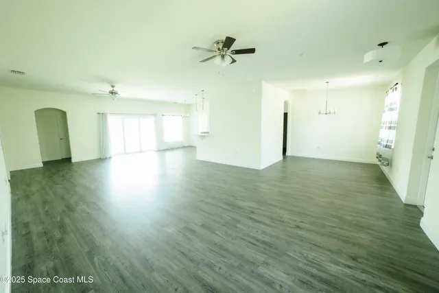 a view of a room with wooden floor and a ceiling fan
