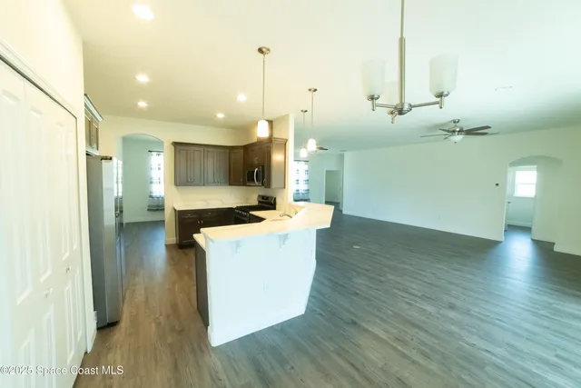 a kitchen with kitchen island a stove a counter top space and wooden floor