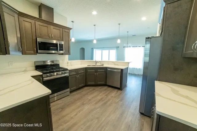 a kitchen with stainless steel appliances a stove sink microwave and cabinets