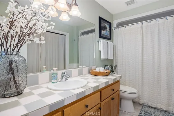 a bathroom with a granite countertop sink and a toilet