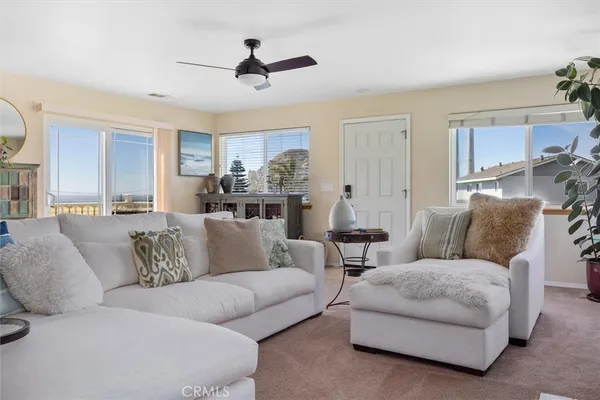 a living room with furniture and a ceiling fan