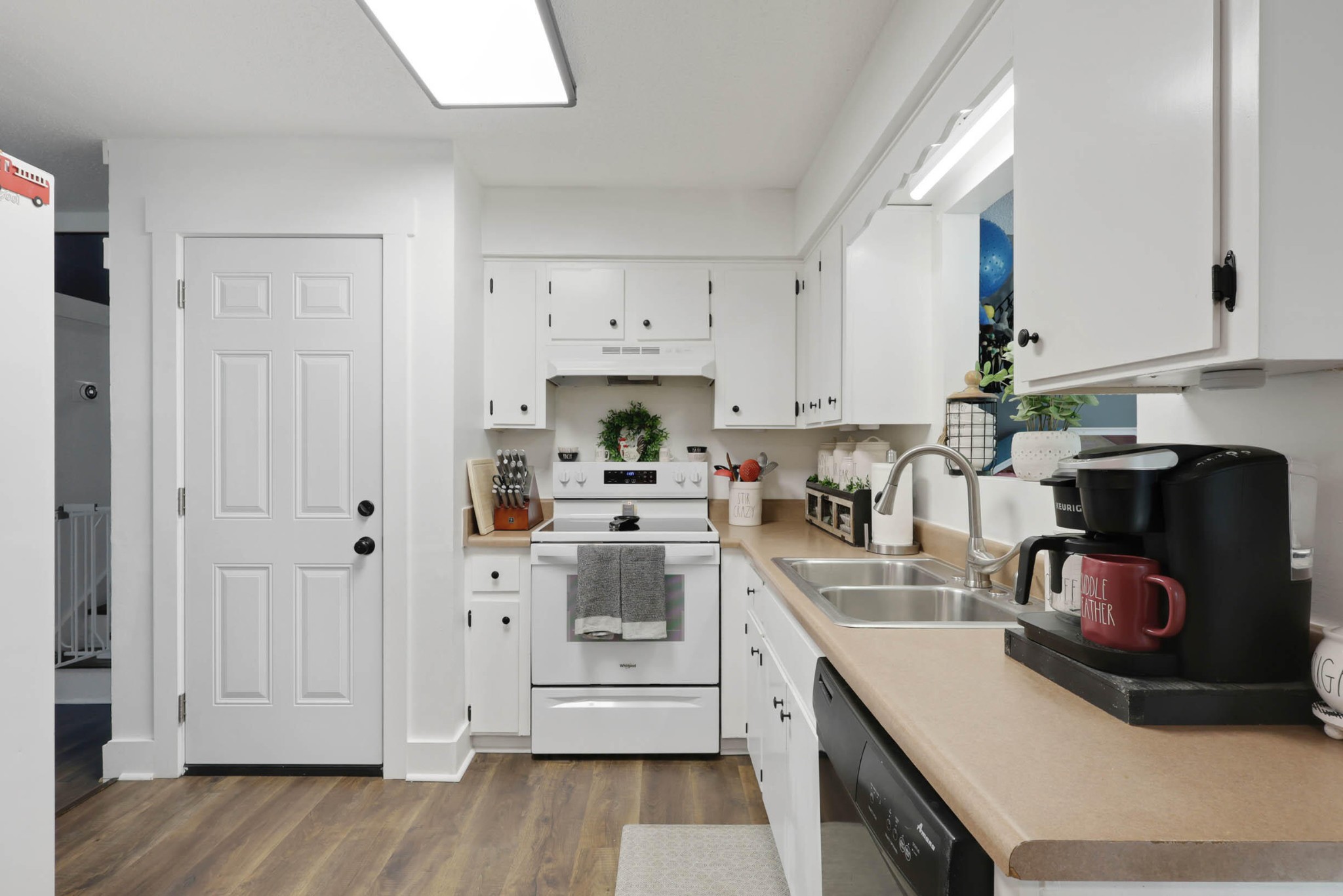 1881 Three Notch Road Ringgold, GA 30736 - Photo 9 of 27 a kitchen with stainless steel appliances granite countertop a sink dishwasher stove and white cabinets with wooden floor